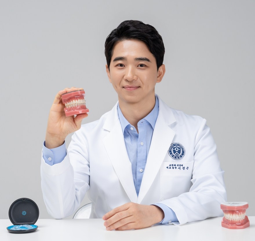 대표원장이 치아 모형을 든 모습입니다.